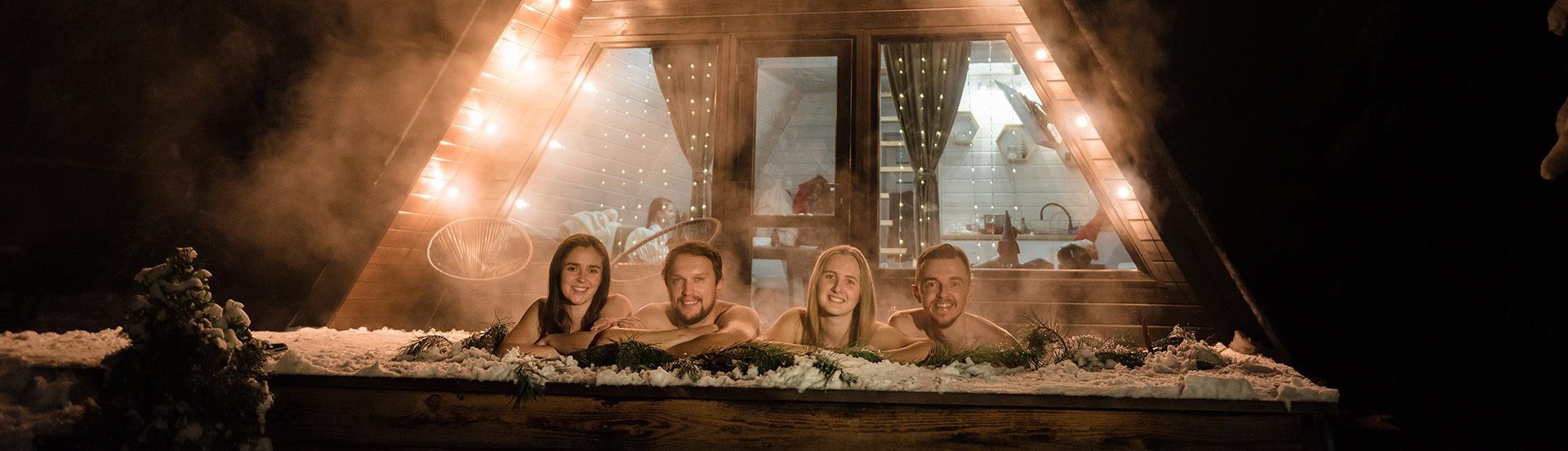 People enjoying hot tub in snowy mountain setting